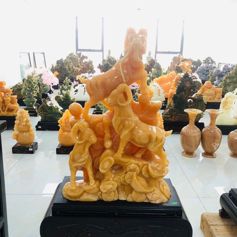 Tượng Tam Dương tựa Hoàng Sơn phú quý là sản phẩm khắc họa hình ảnh ba chú dê đứng trên ngọn núi toàn đồng tiền và thỏi vàng.